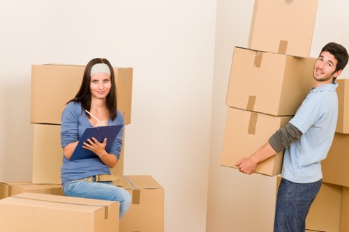 Movers carrying furniture through a Kensington building staircase